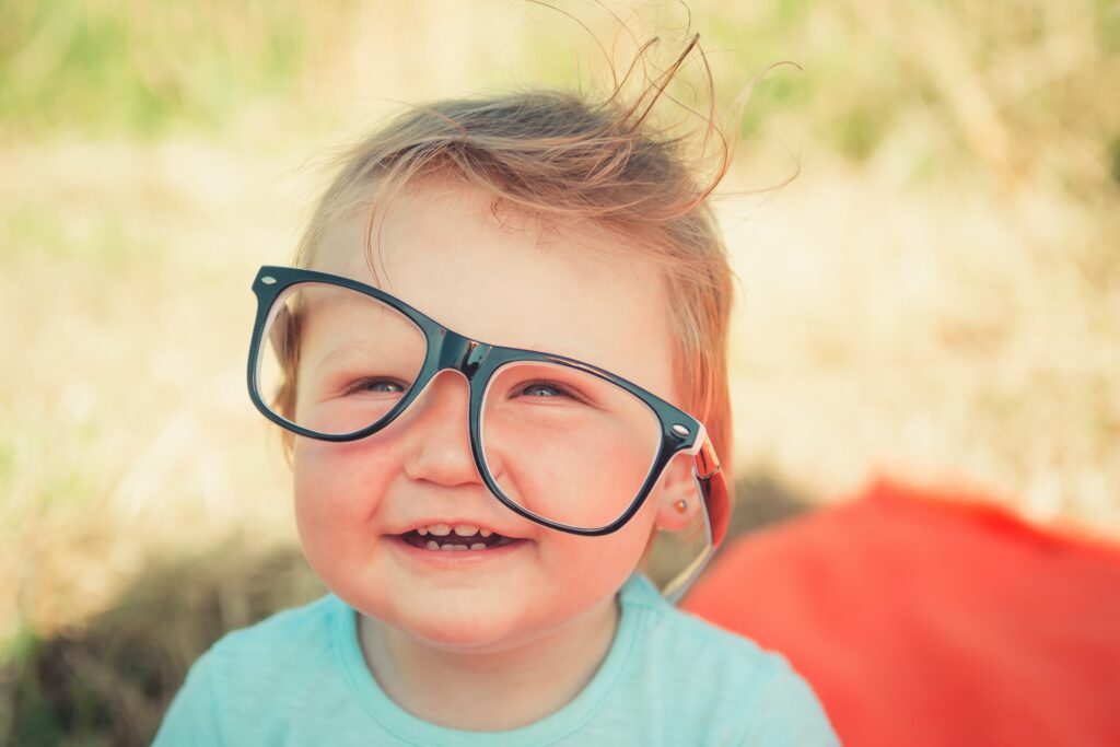 The kid is wearing blue light-blocking glasses. Appealing image showing the benefit of blue light blocking glasses